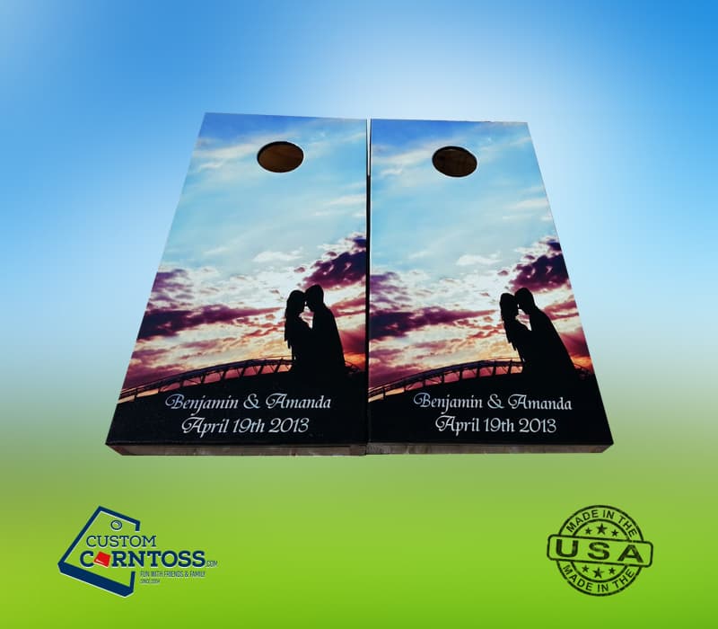 Custom wedding cornhole boards with a full-wrap sunset photo of the couple, their names, and the wedding date