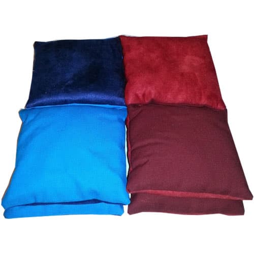 Stacked cornhole bags in navy, red, light blue, and maroon with suede and duck cloth sides