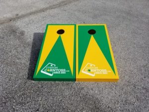 Custom Corntoss kelly green and yellow triangle designed custom cornhole boards on pavement